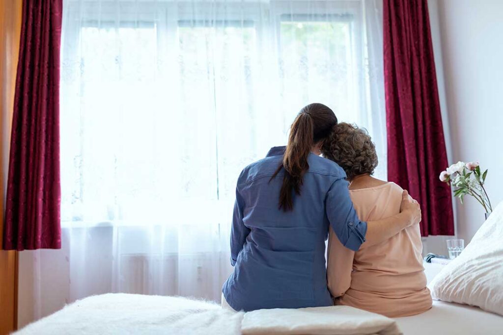 Social worker speaking with an assisted living resident and family member at a table with care notes.